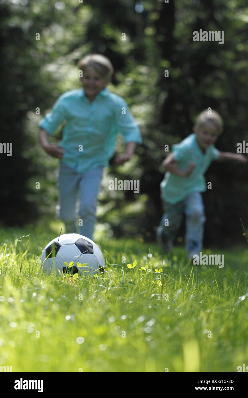 Happy children playing football in summer park Stock Photo - Alamy