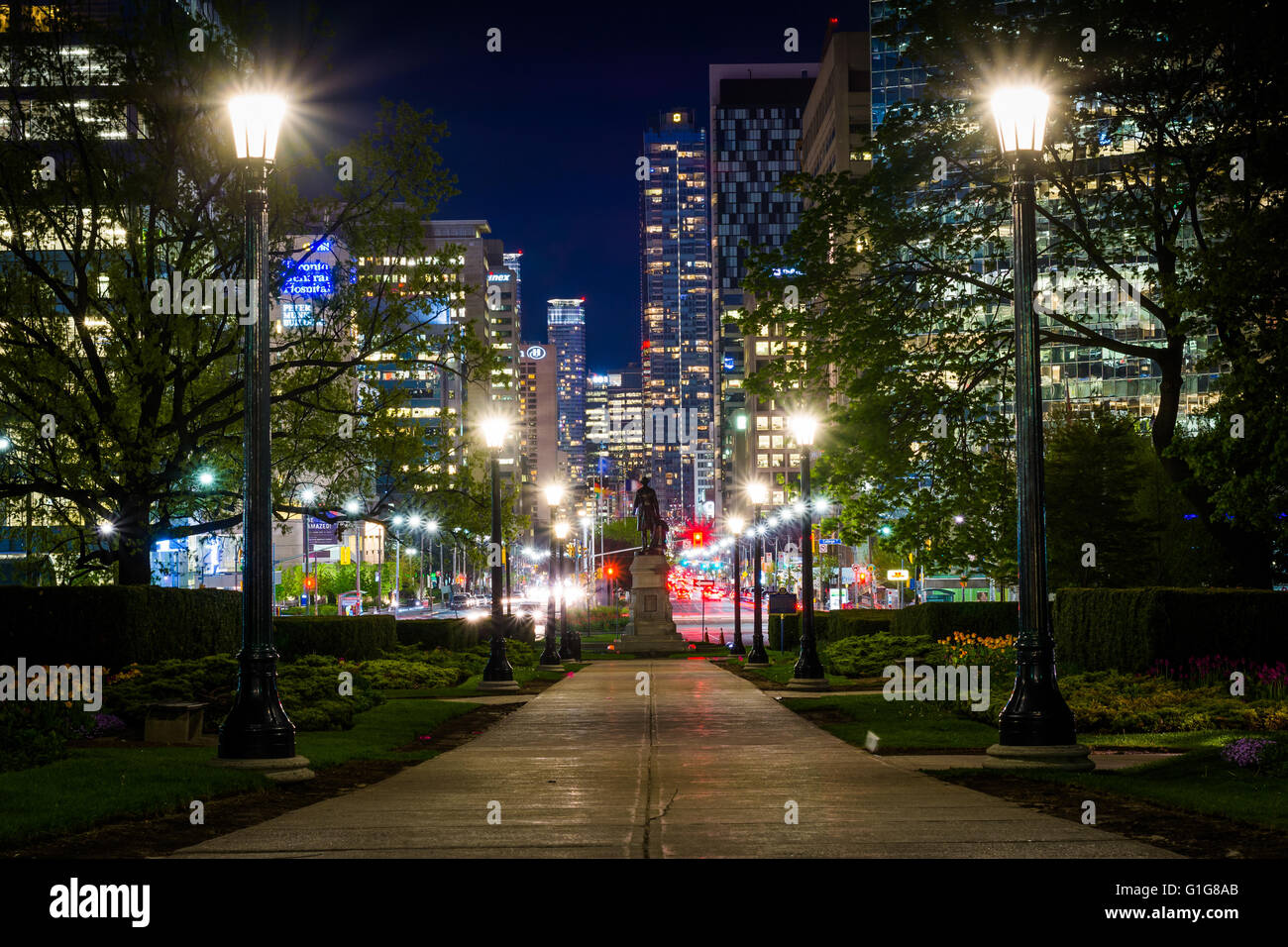Statue and walkway at Queen's Park, and buildings on University Avenue at night, in Toronto, Ontario. Stock Photo