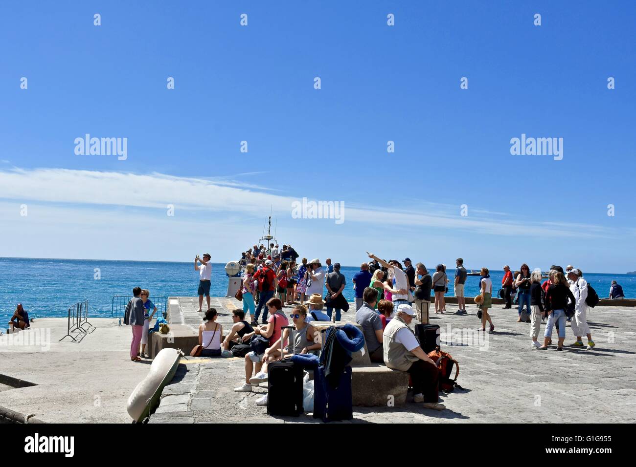 Tourists waiting at the ferry port for the ferry to arrive in Positano Italy Stock Photo