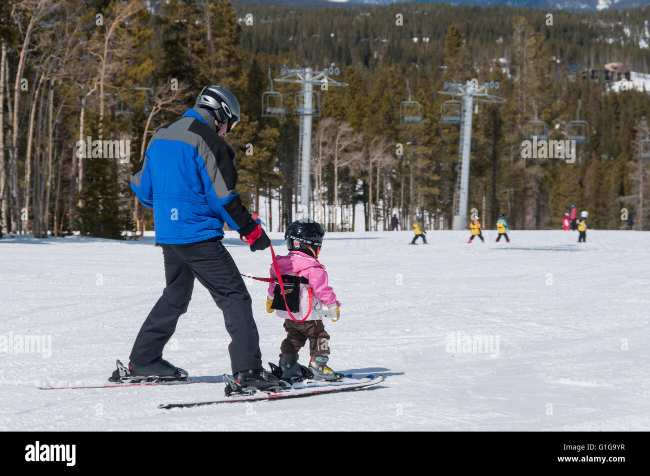 Father skiing with daughter with a harness, Silverthorne Trail, Peak 9