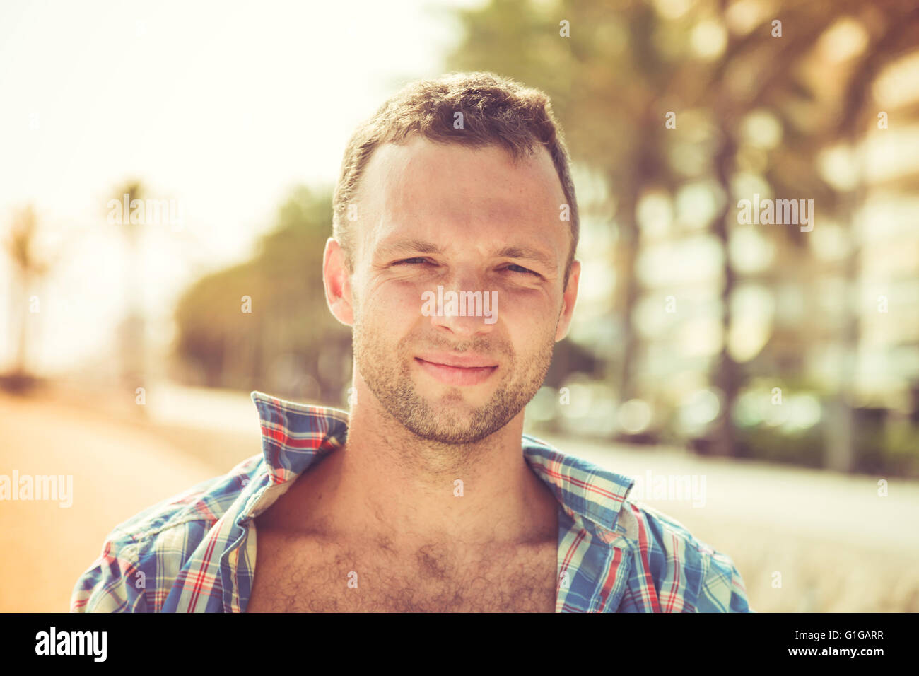 Young smiling handsome Caucasian man, outdoor portrait in sunny day Stock Photo