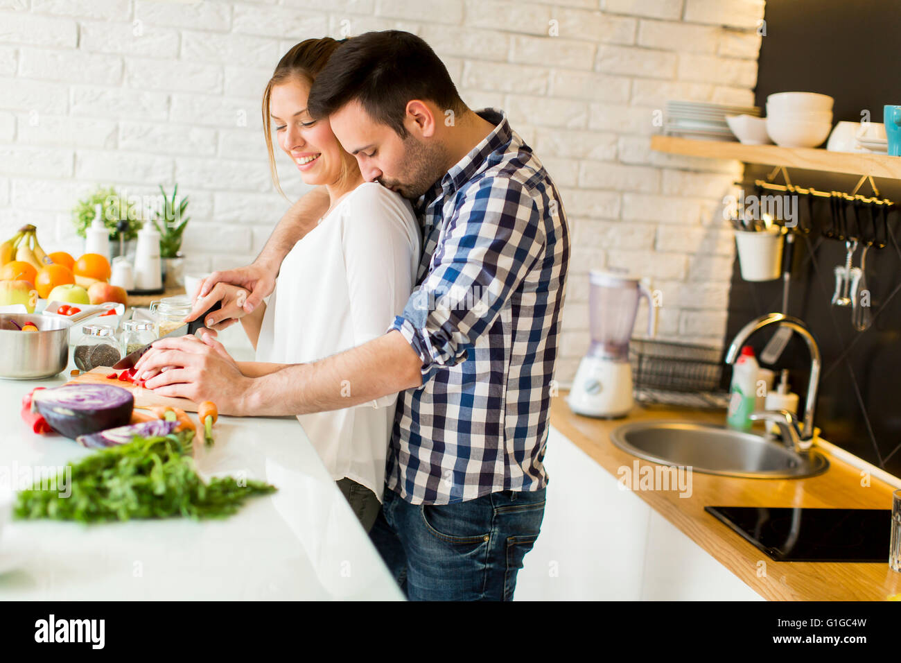 Loving couple preparing healthy food in modern kitchen Stock Photo