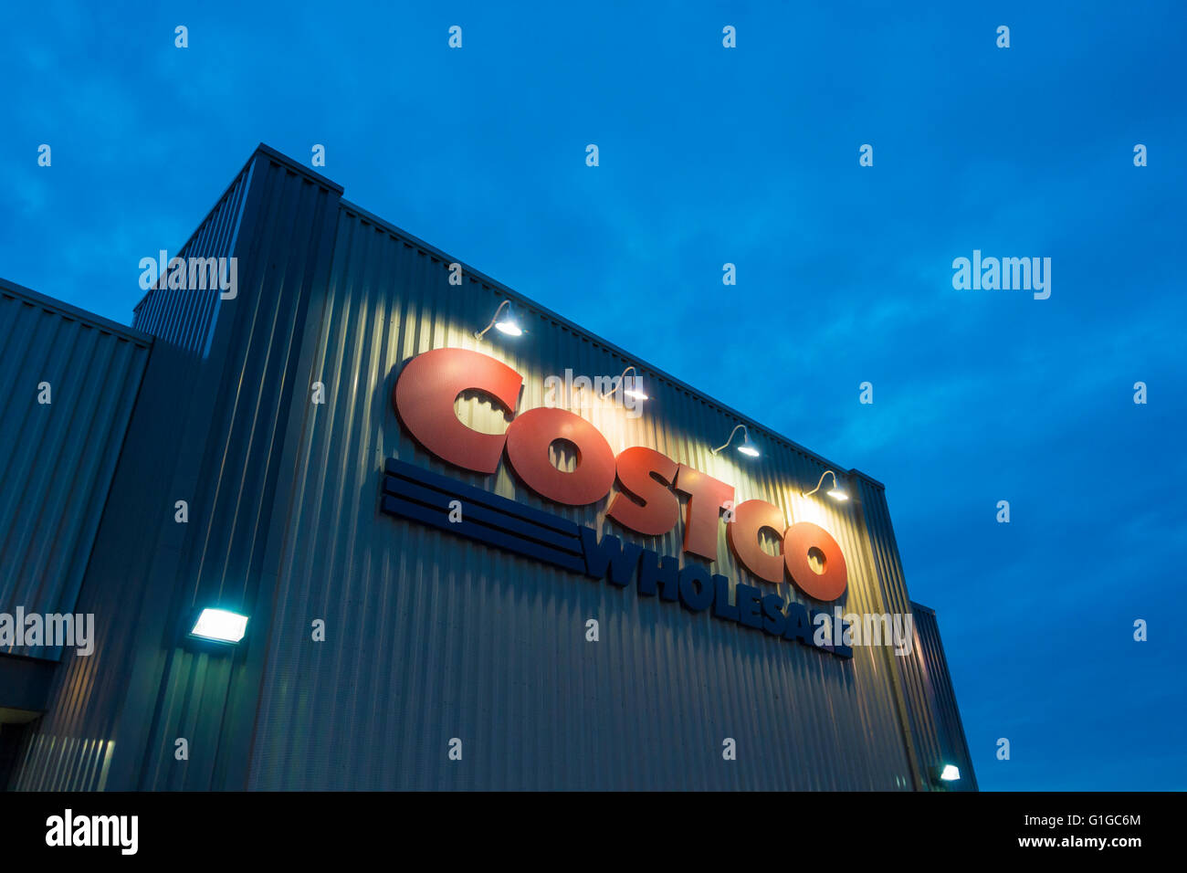 A sign for Costco Wholesale illuminated at dusk. Oakville, Ontario, Canada. Stock Photo