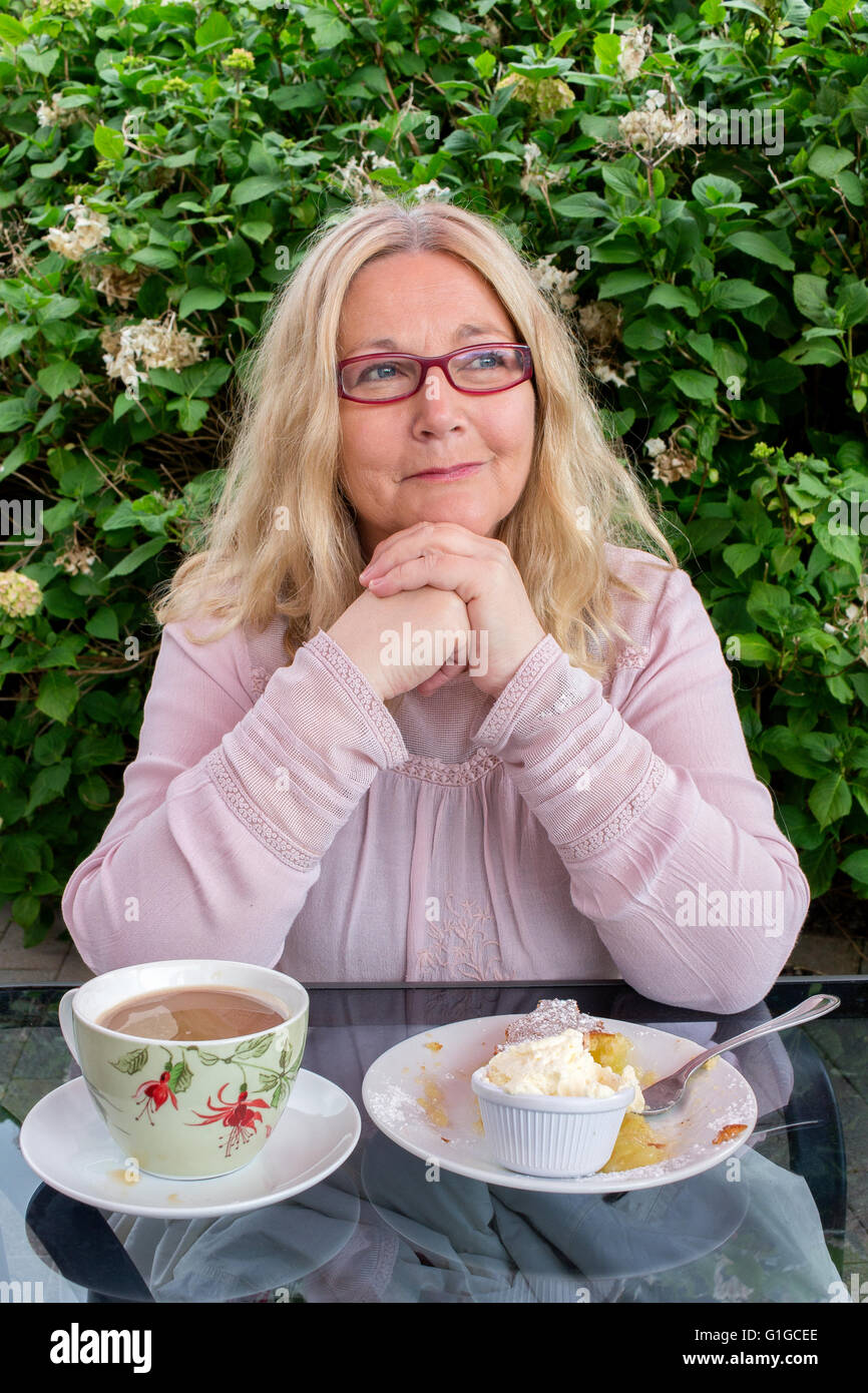 Attractive older woman with cake and coffee. Stock Photo
