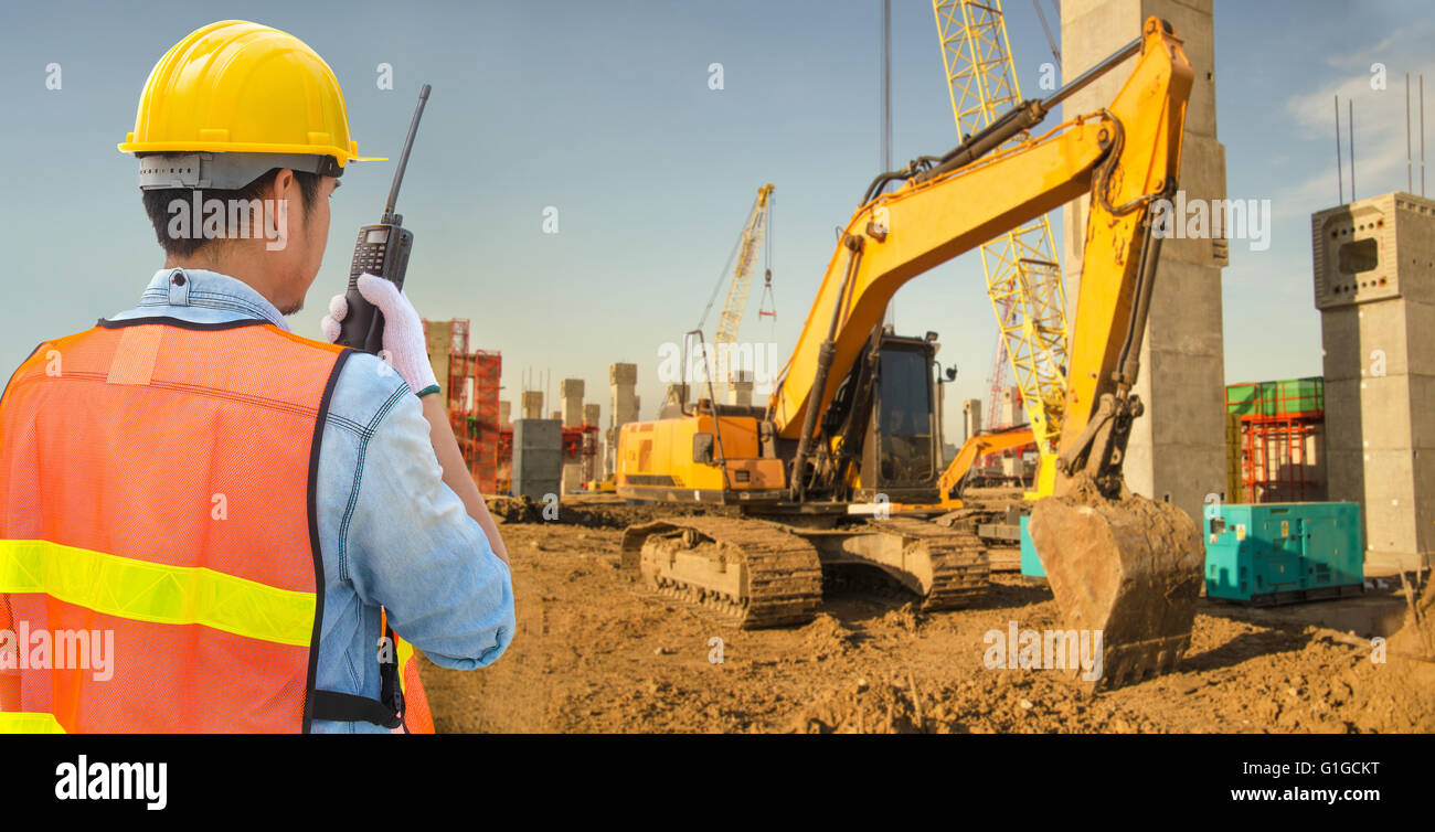 Confident supervisor using walkie-talkie at construction site Stock ...