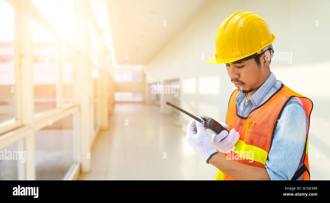 Confident supervisor using walkie-talkie at construction site Stock Photo