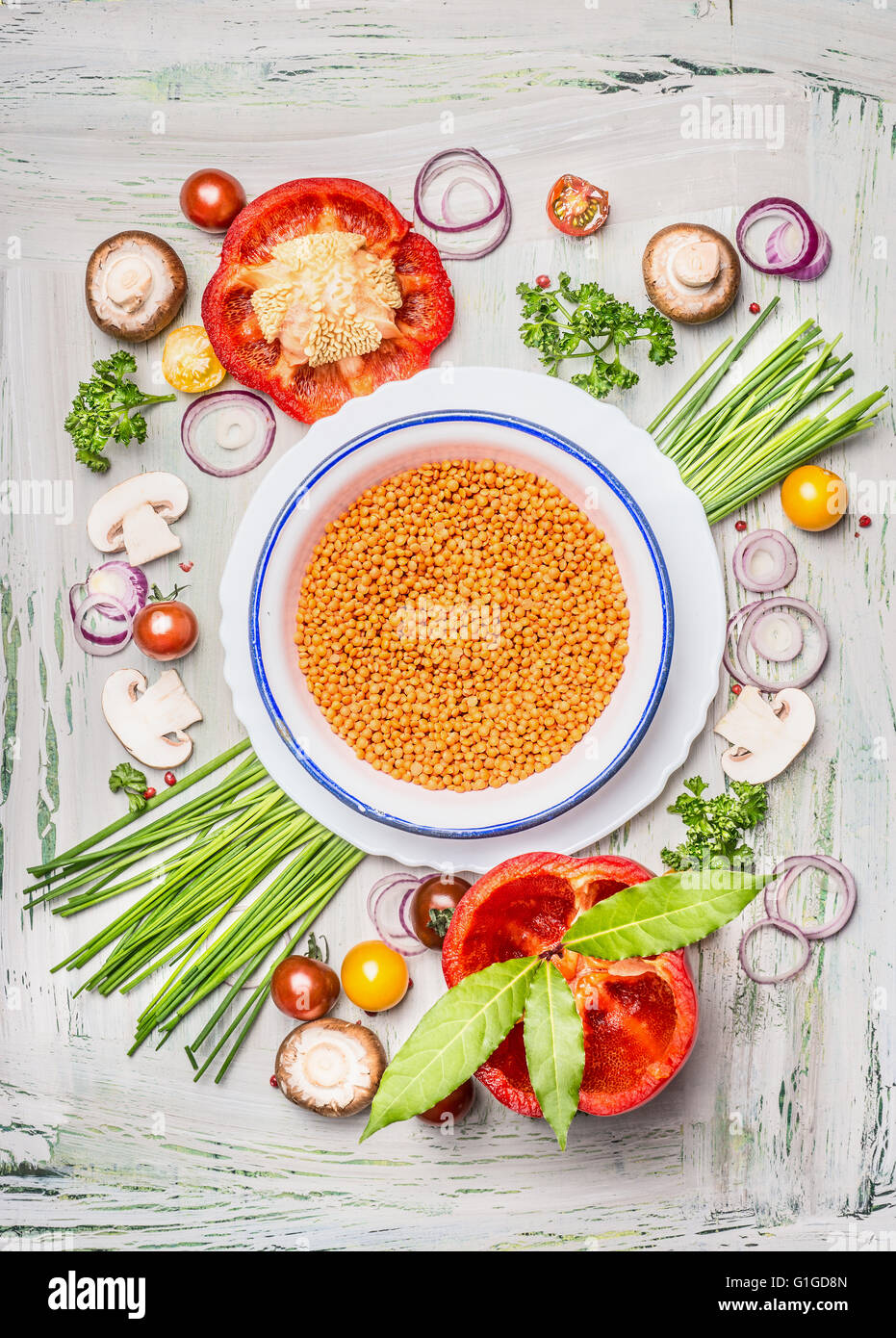 Red lentil in bowl and vegetables ingredients for healthy vegetarian cooking, top view composing. Stock Photo