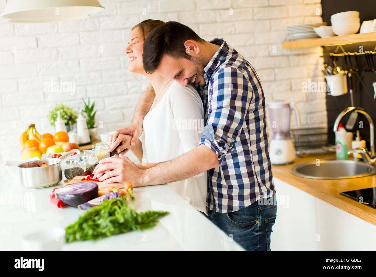 Loving couple preparing healthy food in modern kitchen Stock Photo