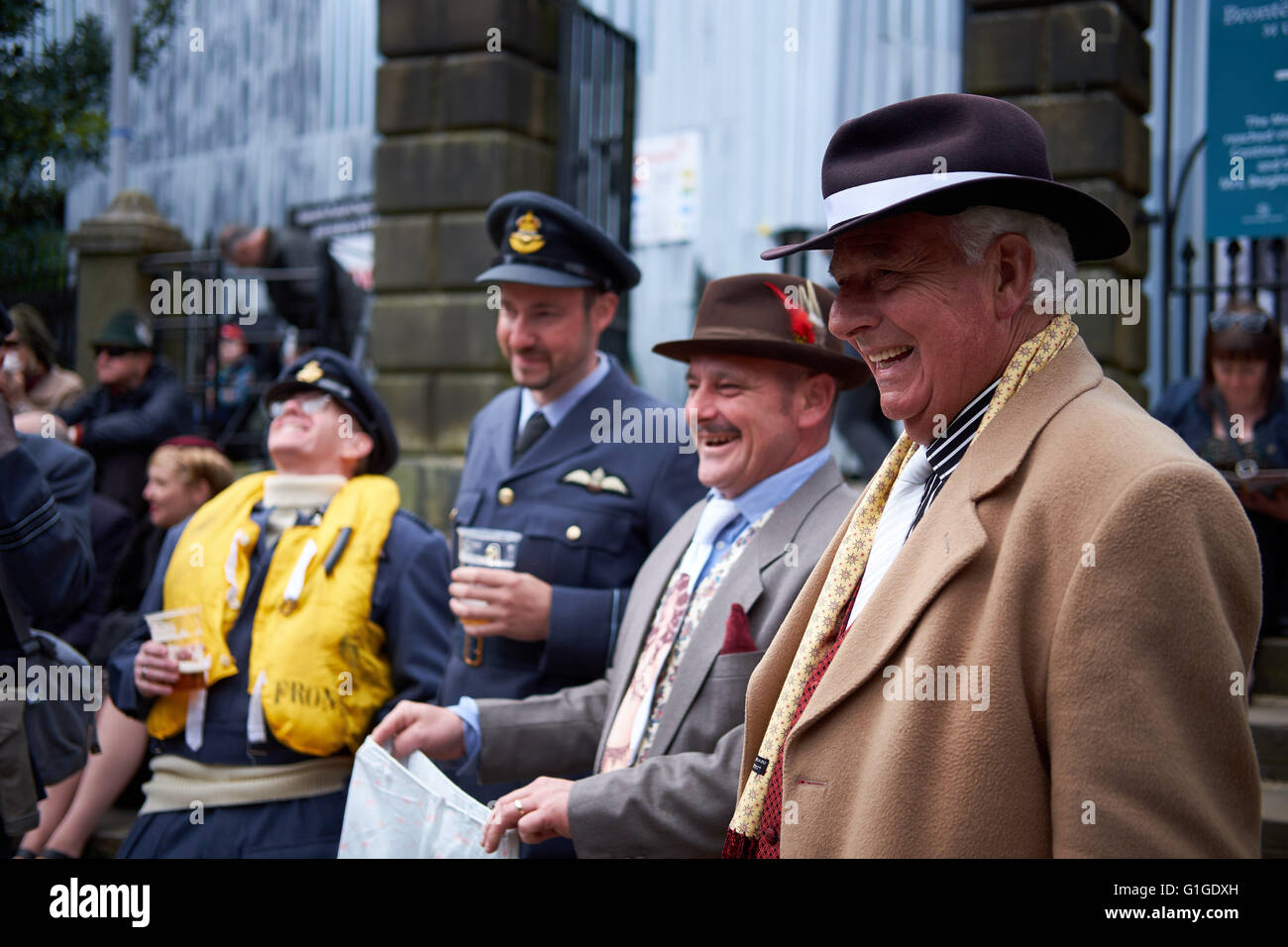 Four men, two in RAF uniform and two dressed in 1940s vintage clothing, at a reenactment event. Stock Photo