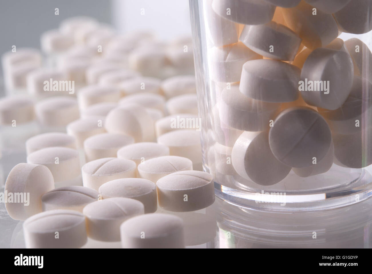 white pills and clear bottle close up Stock Photo