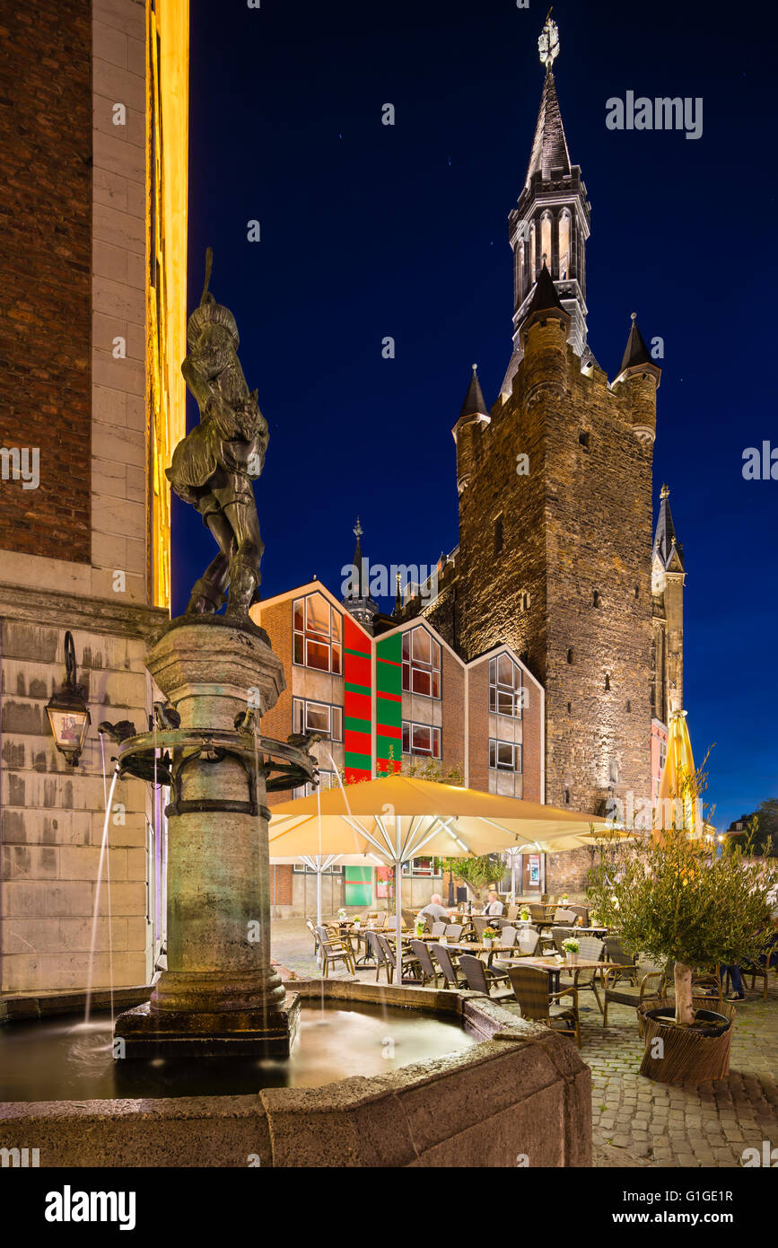 Side view of the old town hall of Aachen, Germany with night blue sky. A cafe and a fountain in the foreground. Taken with a shi Stock Photo