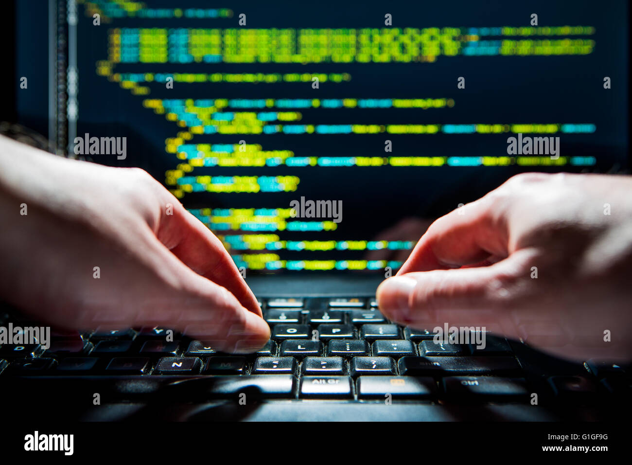 Hacker using laptop. Lots of digits on the computer screen. Stock Photo