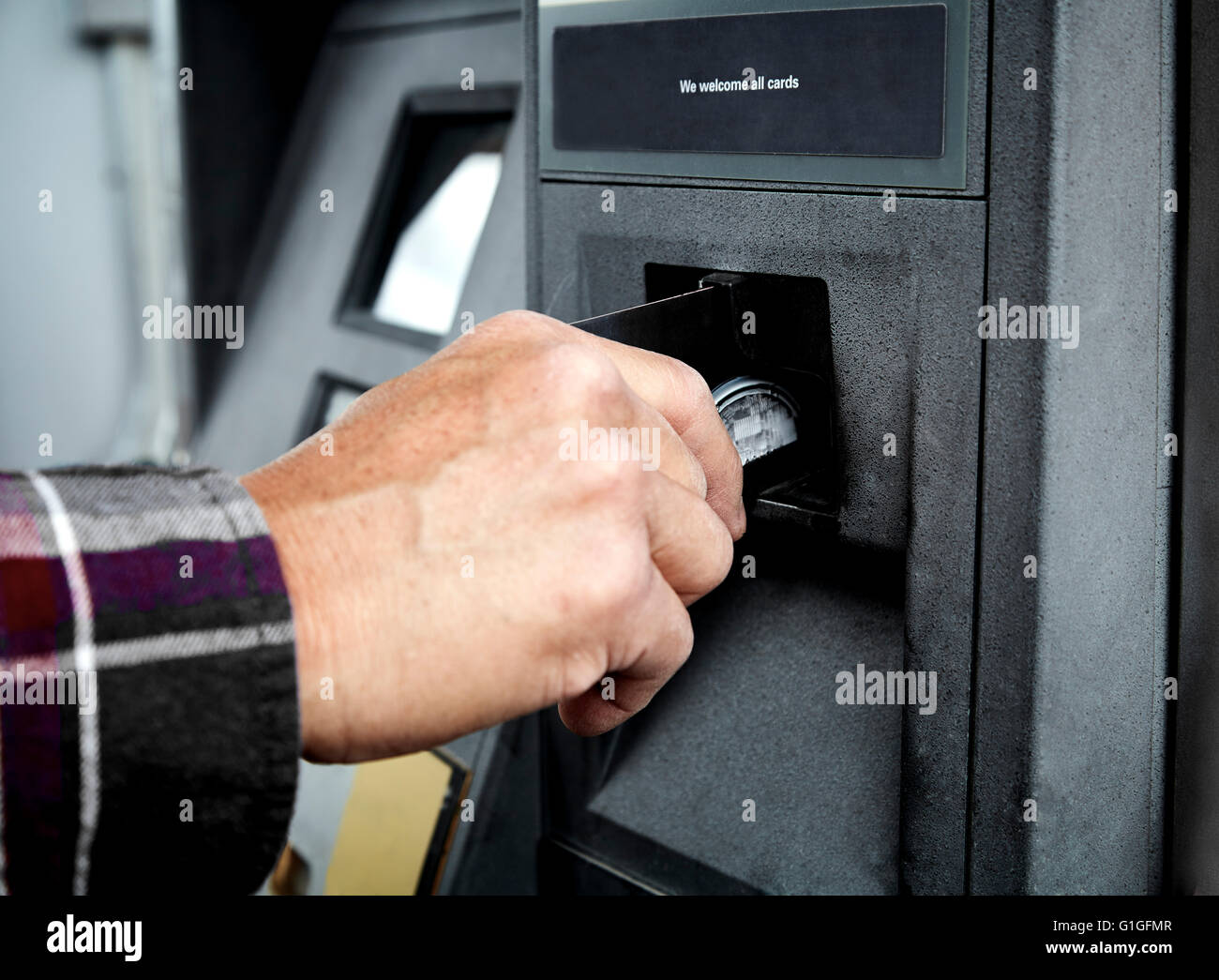 Mans Hand putting a debit card in an ATM machine to withdraw cash Stock