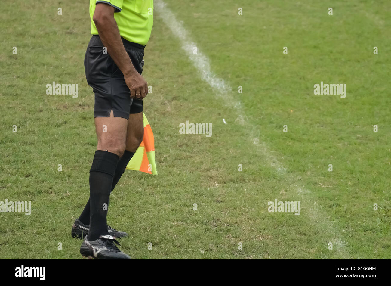 Soccer assistant referee running with flag Stock Photo Alamy