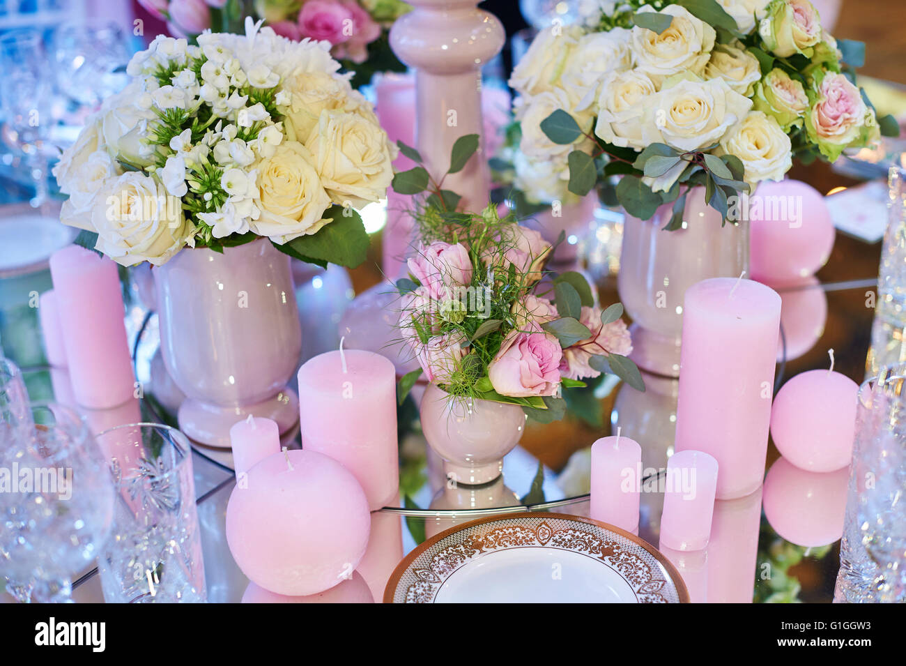 Table set for wedding reception with candles and flower bouquets Stock Photo