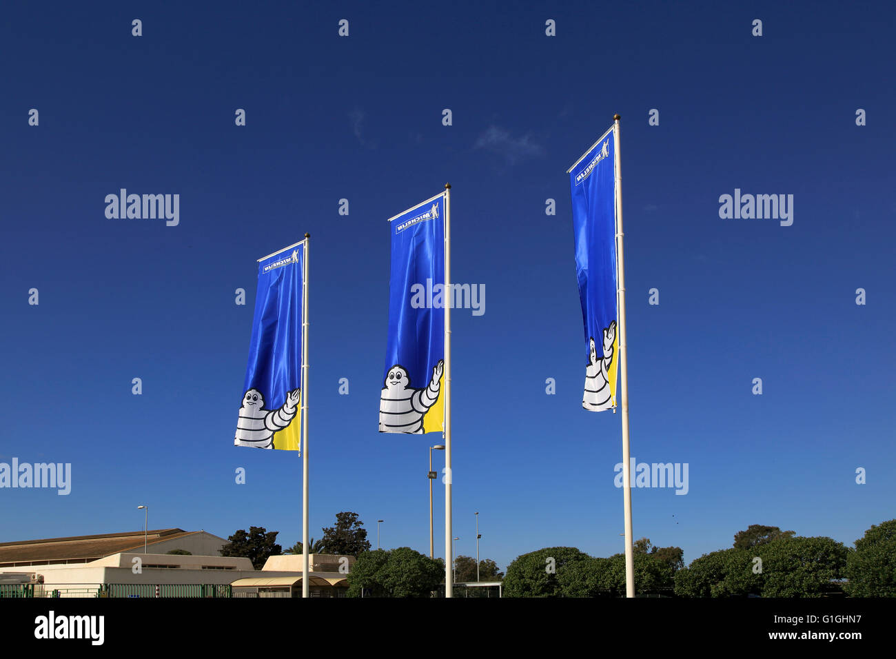 Company flags with logo Bibendum figure flying outside, Michelin factory and research establishment, Almeria, Spain Stock Photo