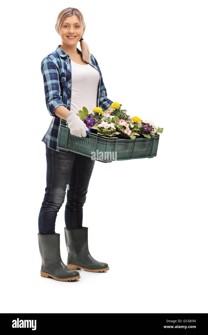 Full length portrait of a cheerful female gardener holding flowers ...