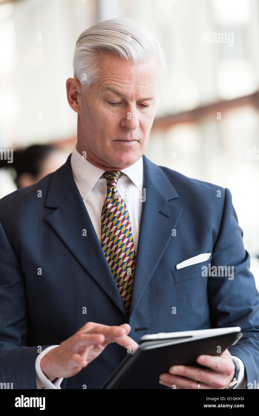 Handsome Senior Business Man With Grey Hair Working On Tablet