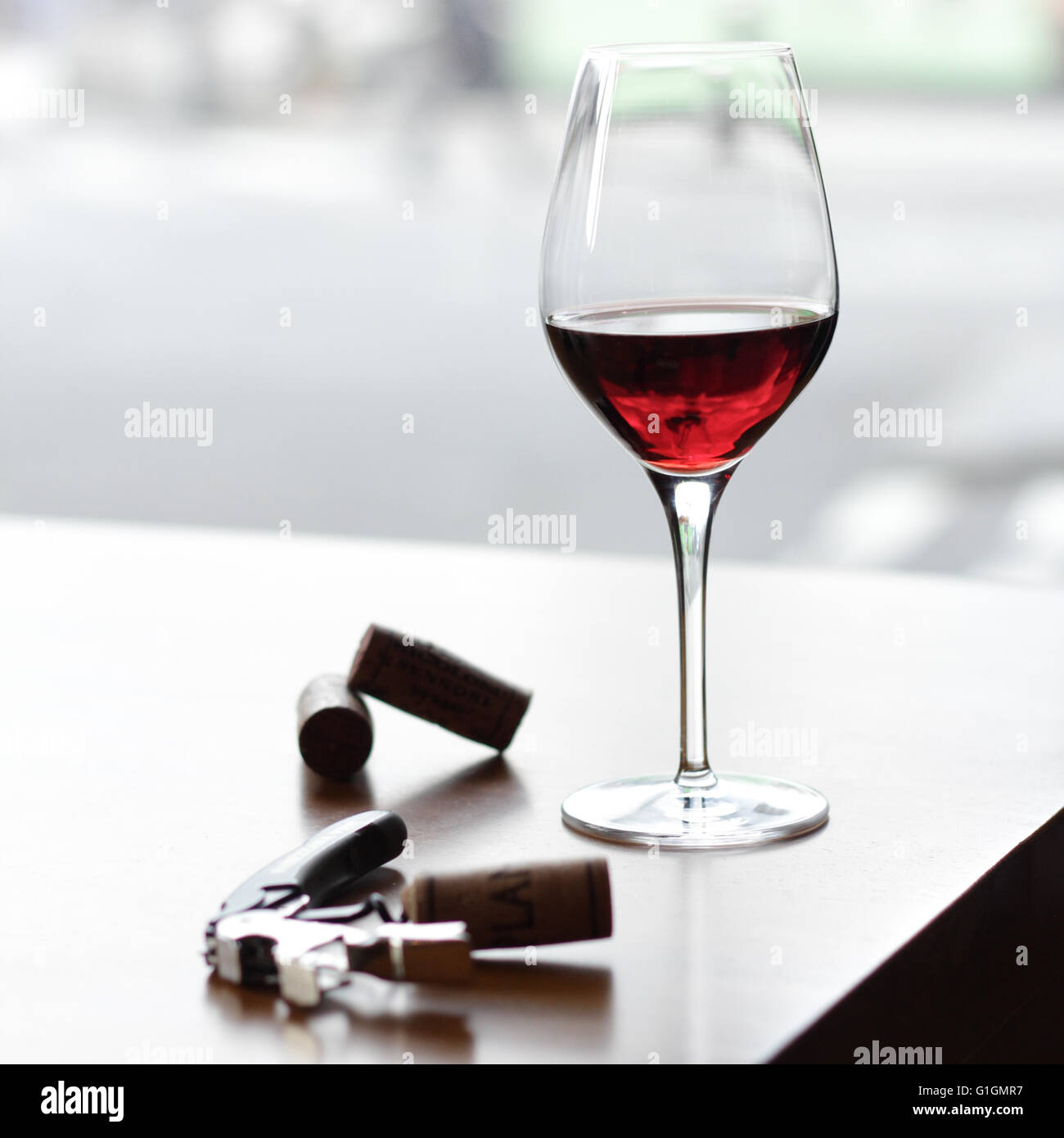 A wine glass sat on a wooden table in a central London Italian winebar. Stock Photo