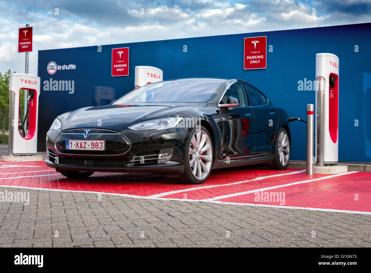 Tesla Electric car on a charging station at Euro Tunnel terminal Folkstone UK Stock Photo