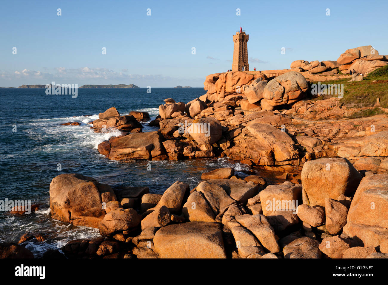 Lighthouse and pink rocks at sunset, Ploumanach, Cote de Granit Rose, Cotes d'Armor, Brittany, France, Europe Stock Photo