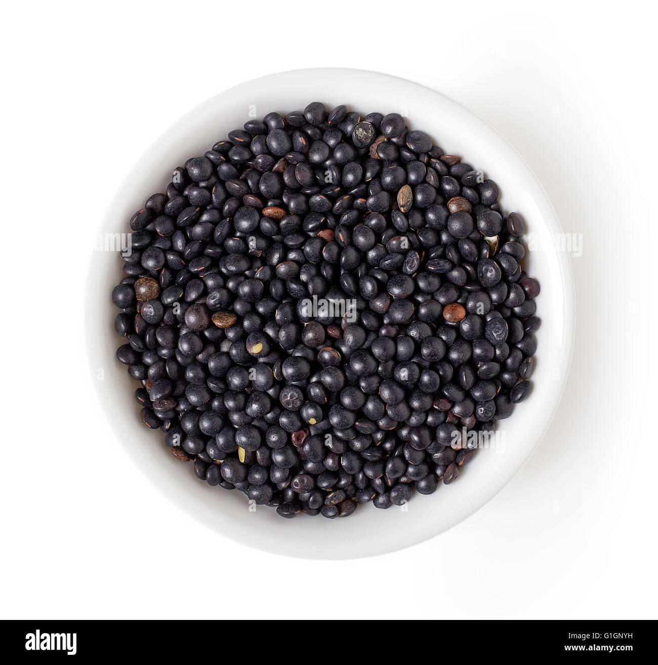 Bowl of Beluga black lentil isolated on white background, top view Stock Photo