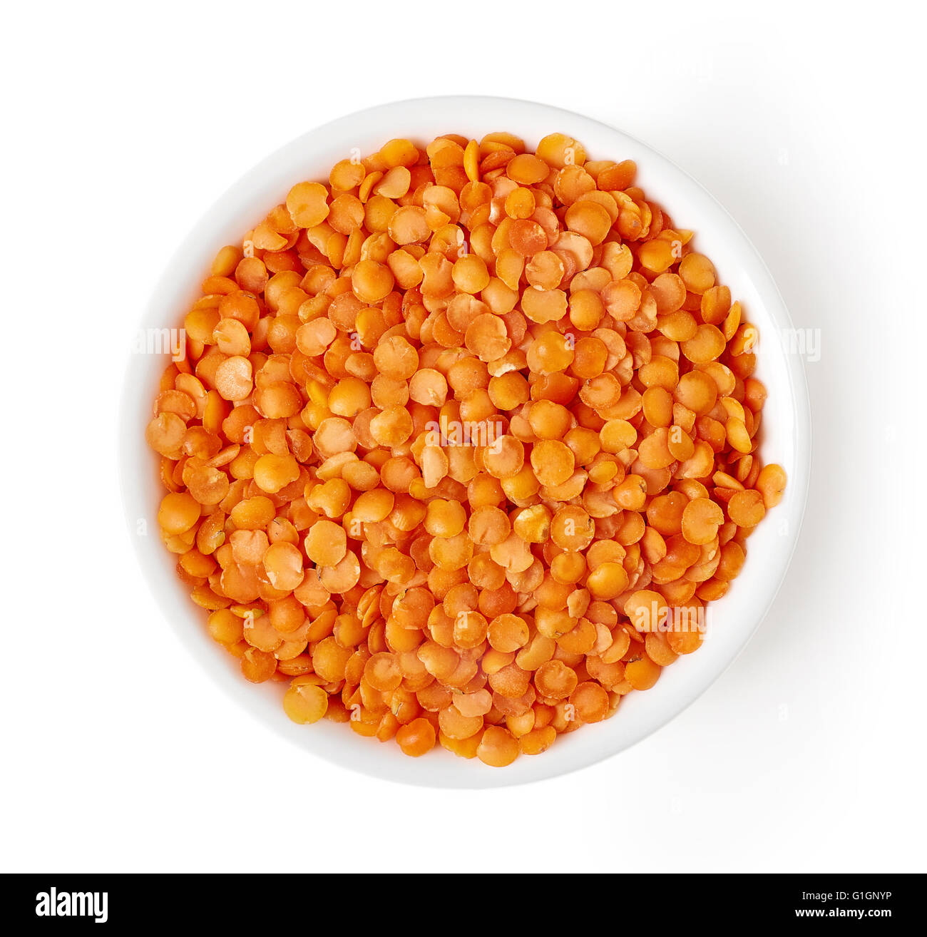 Bowl of red split lentil isolated on white background, top view Stock Photo
