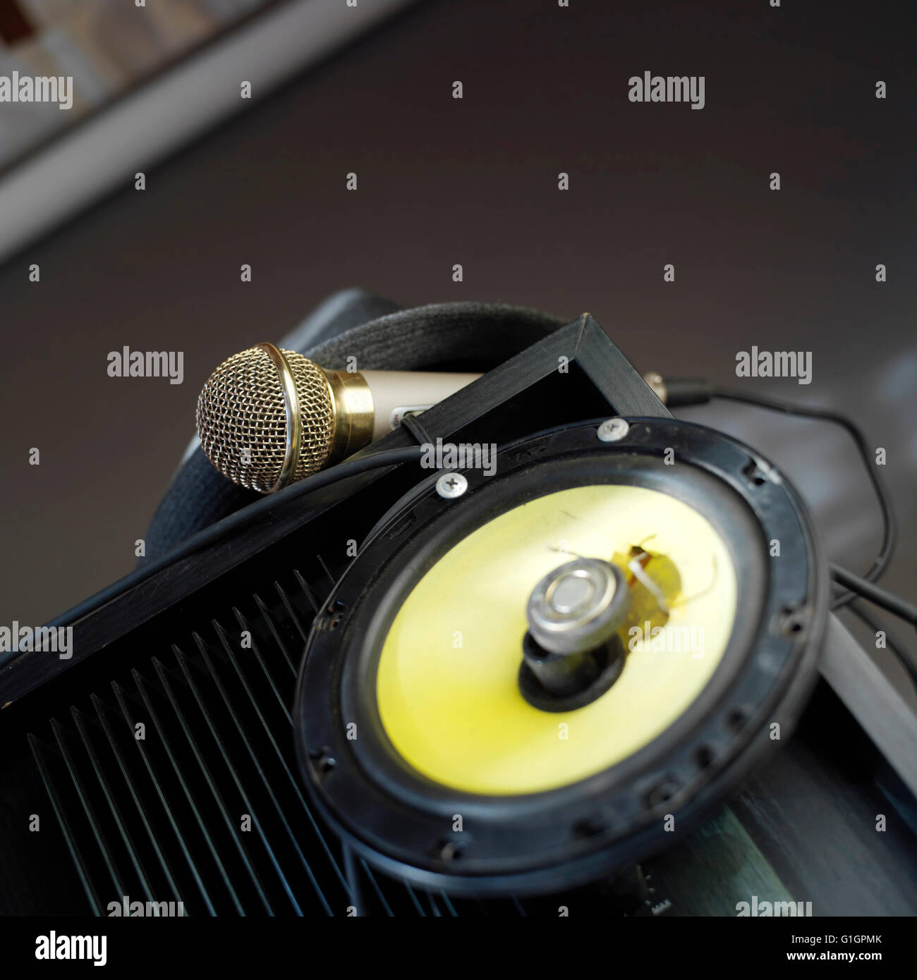 Microphone laid on an amplifier, loudspeaker on the blurred foreground ...