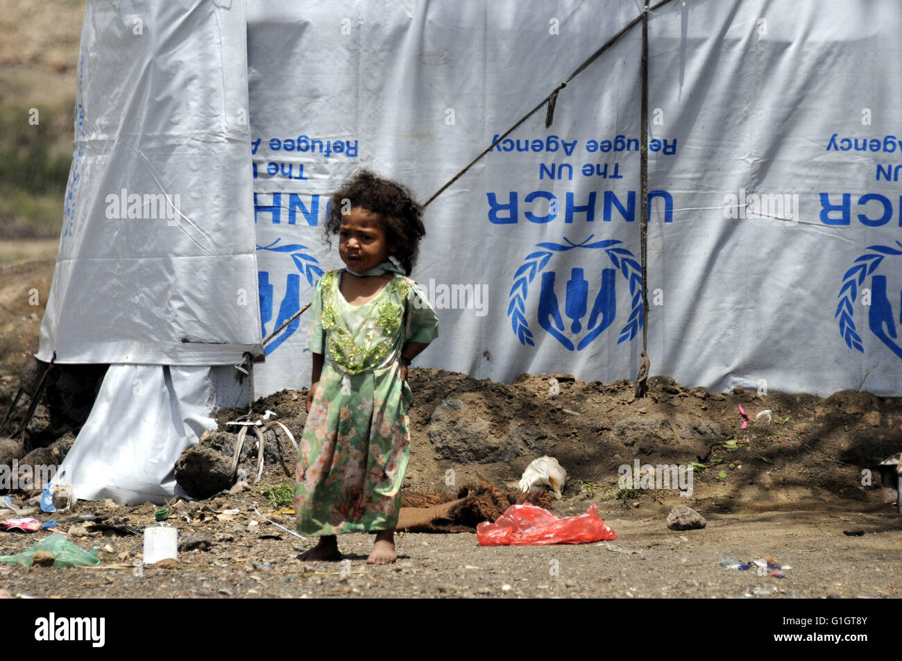 Sanaa, Yemen. 14th May, 2016. A Yemeni internally displaced child stands outside her makeshift shelter at a camp on the outskirts of Amran province, Yemen, on May 14, 2016. The ongoing conflict in Yemen has forcibly displaced more than 2.4 million people in Yemen. © Hani Ali/Xinhua/Alamy Live News Stock Photo