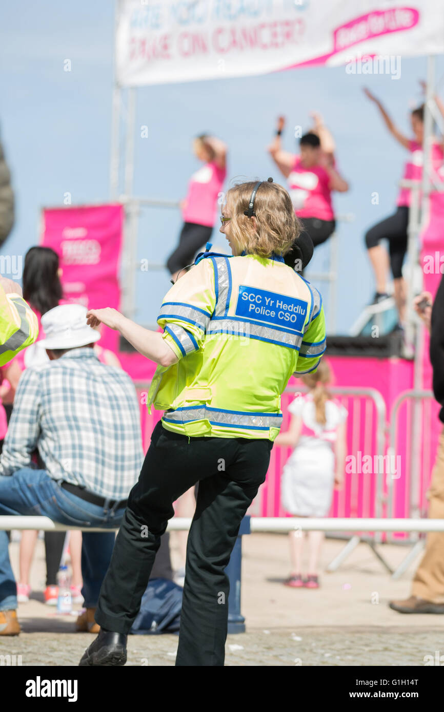 Aberystwyth, Ceredigion, Wales, UK 15th May 2016. Cancer research 2016 UK’s Race for Life at Aberystwyth. A police woman and a PCSO show support on the warmup dance by joining in on the fun. Women and girls of all ages race along the promenade of Aberystwyth on this bright sunny day while taking part in the annual cancer research charity fund raising event. In 2016 Cancer Research UK hopes that Race for Life will raise £50 million. Credit:  Ian Jones/Alamy Live News Stock Photo