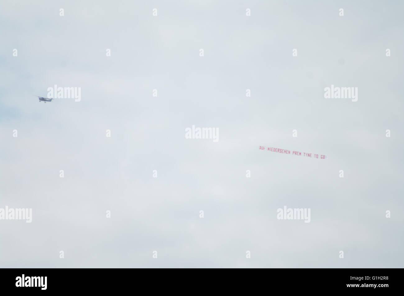 Newcastle upon Tyne, UK, 15 May 2016. A plane pulling a banner saying “Auf Wiedersehen Prem Tyne to Go” flies around St James Park as Newcastle play their final match of the 2015/2016 season. They were relegated to the Championship prior to this match. The banner was created by Air Ads and paid for by Sunderland fans with surplus funds being donated to charity. Credit:  Colin Edwards / Alamy Live News Stock Photo