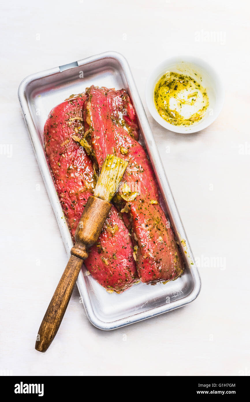 Two fresh lamb fillet marinating for cooking or BBQ grill on white