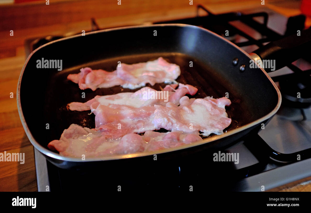 Bacon cooking in a frying pan Stock Photo - Alamy