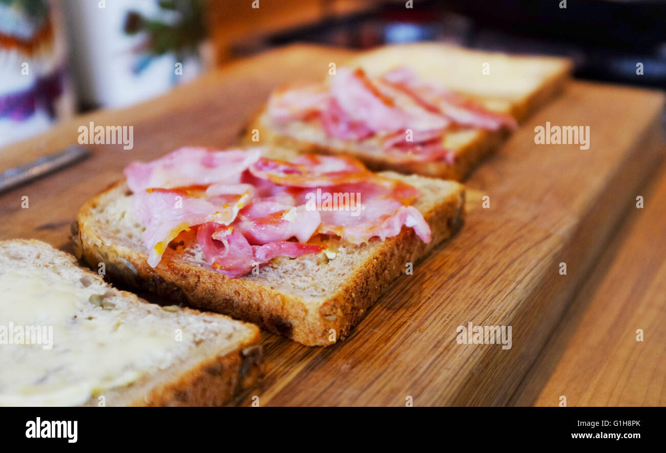 Making a bacon sandwich in brown bread with tomato ketchup or sauce Stock Photo Alamy