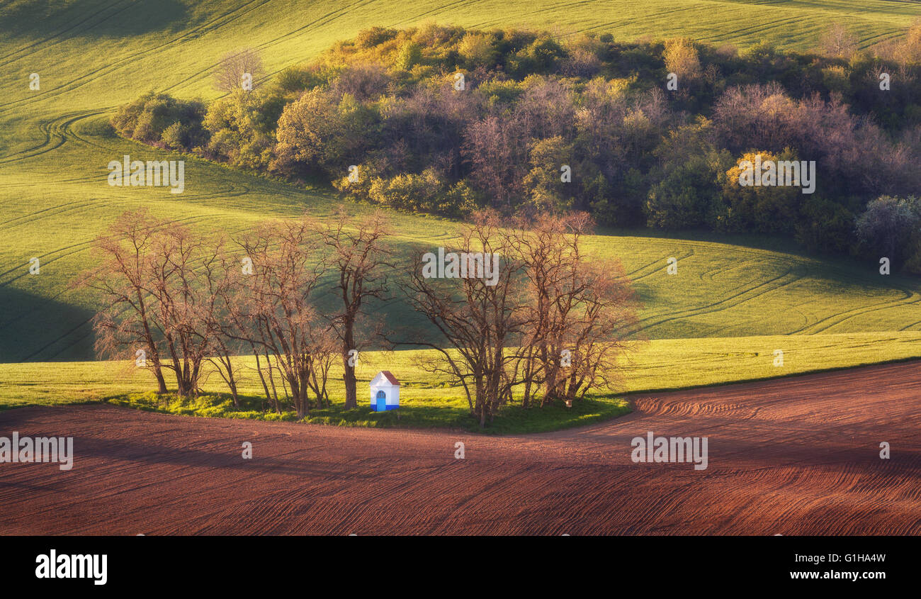 Fairytale spring landscape with famous amazing chapel in beautiful green fields at colorful sunset in South Moravia Stock Photo