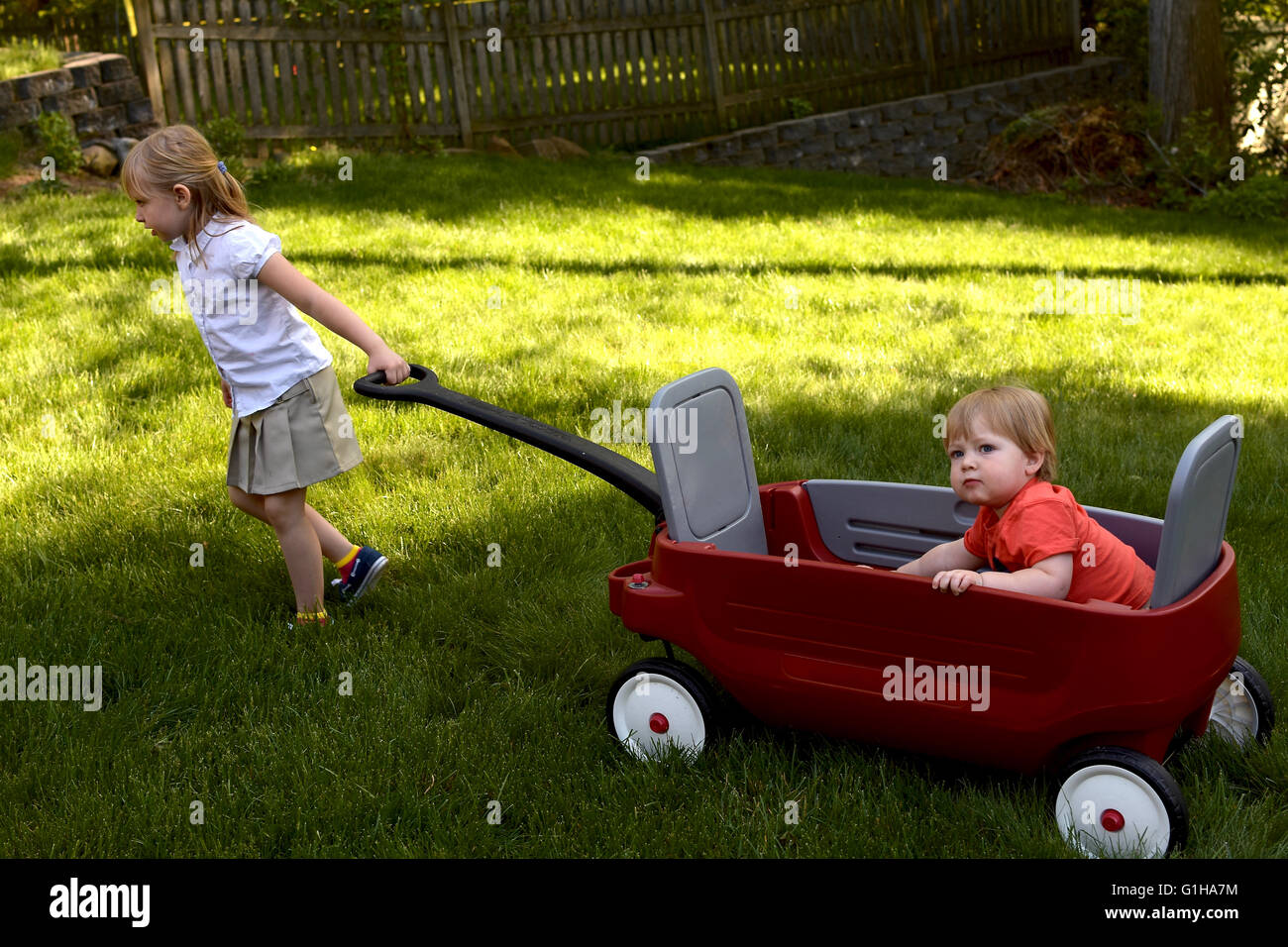sister pulling brother in wagon Stock Photo - Alamy