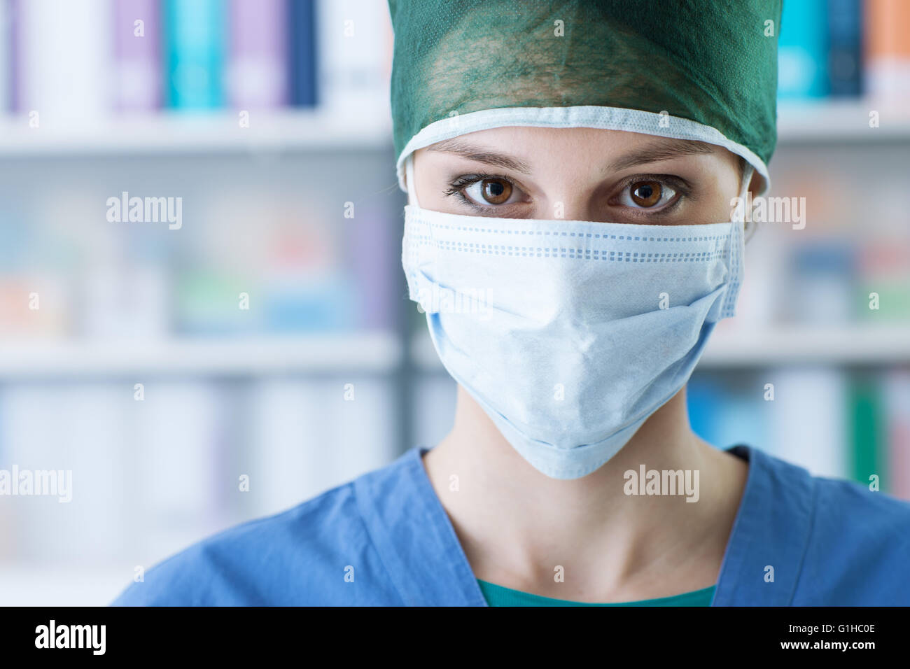 Female surgeon with cap and surgical mask, healthcare and medical procedures concept Stock Photo