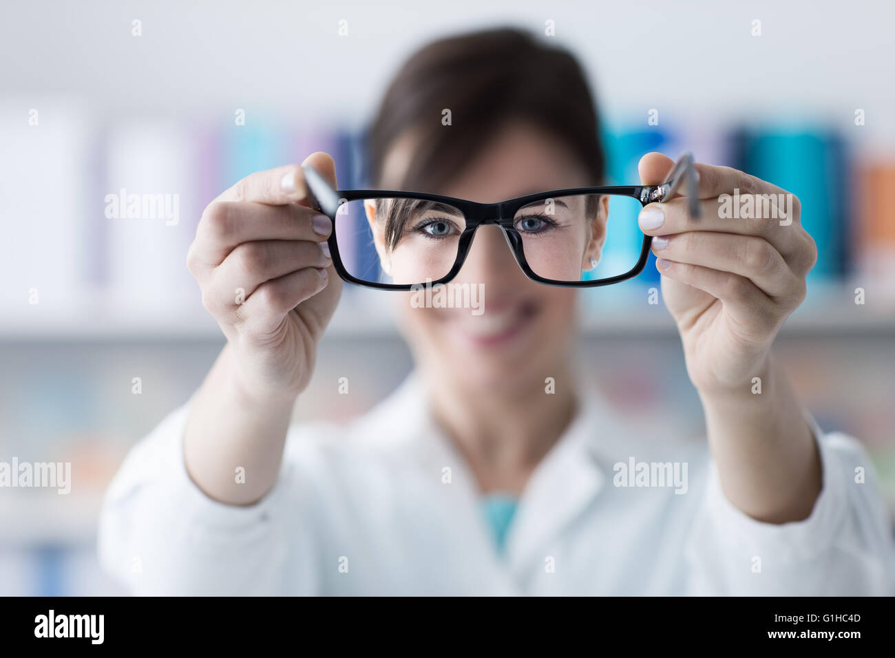 Optometrist giving eyewear to the patient, glasses on foreground, eye care concept, selective focus Stock Photo