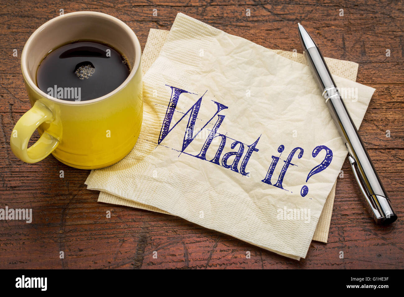 What if question - handwriting on napkin with a yellow cup of espresso coffee against rustic wood Stock Photo