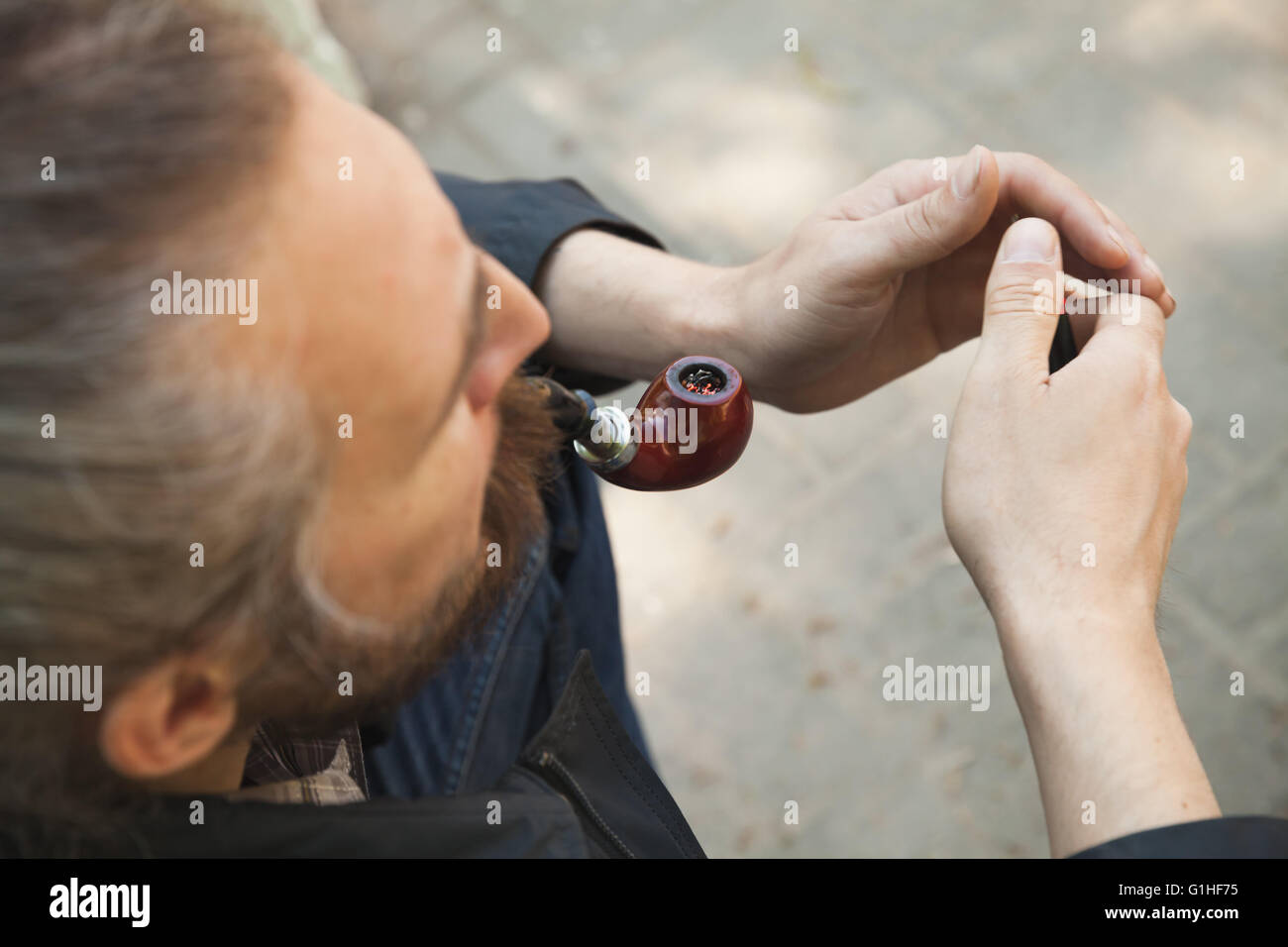 Man smoking pipe, outdoor photo with selective focus Stock Photo