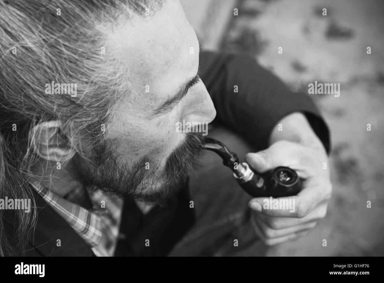 Man smoking pipe, black and white photo with selective focus Stock Photo
