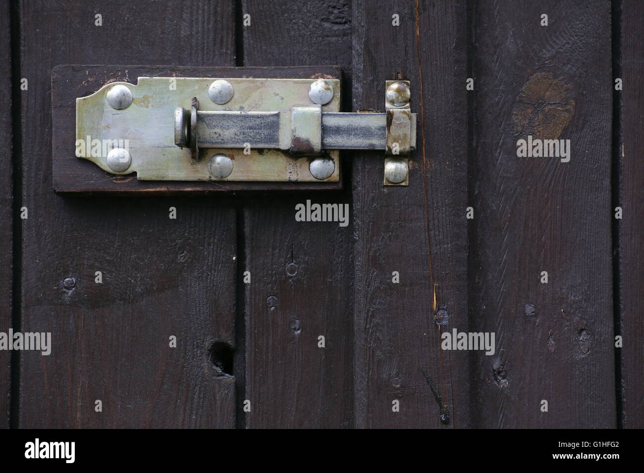 Door latch hanging at the outside of a gate. Stock Photo