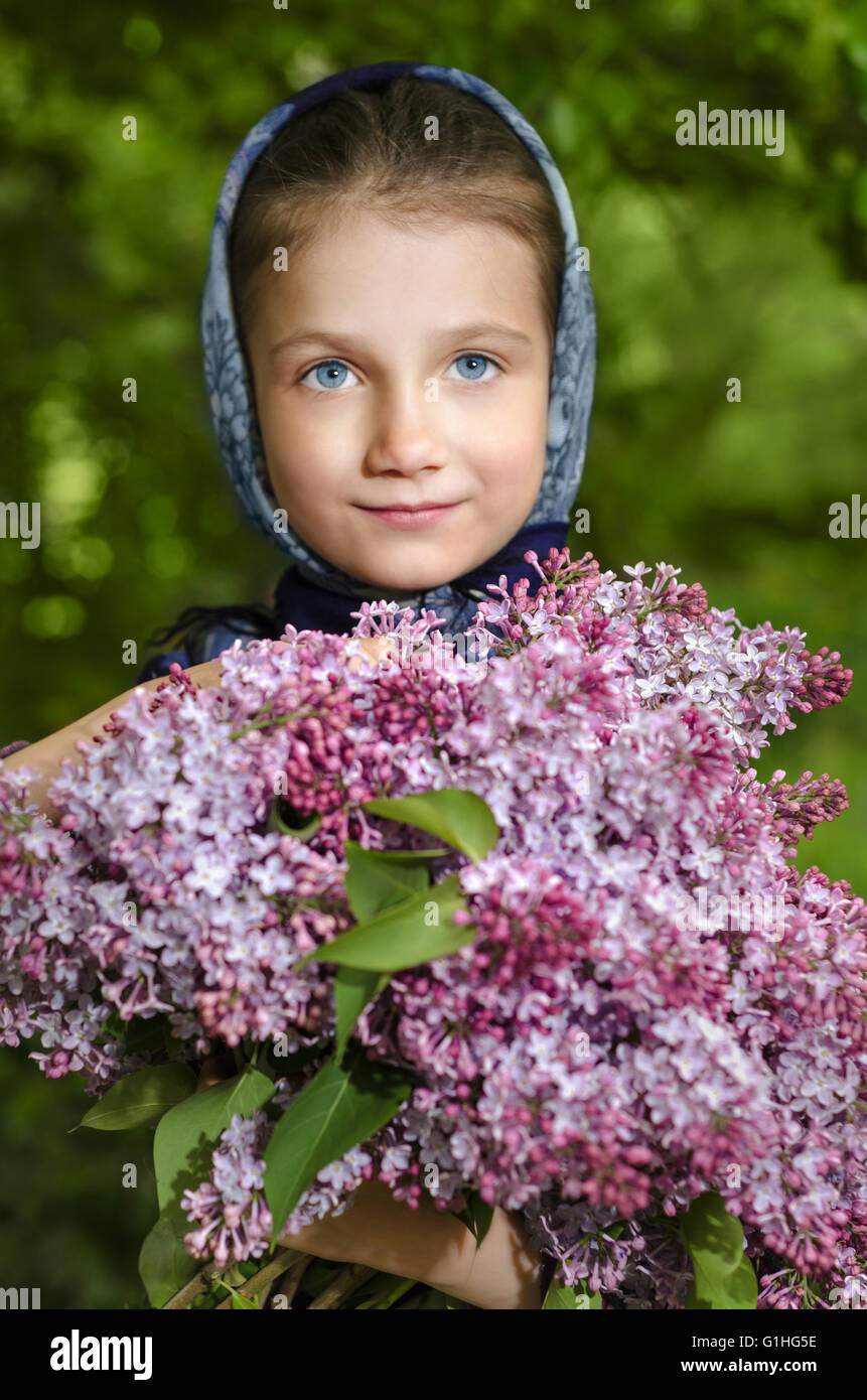 Little girl with lilacs blooming in the hands Stock Photo - Alamy