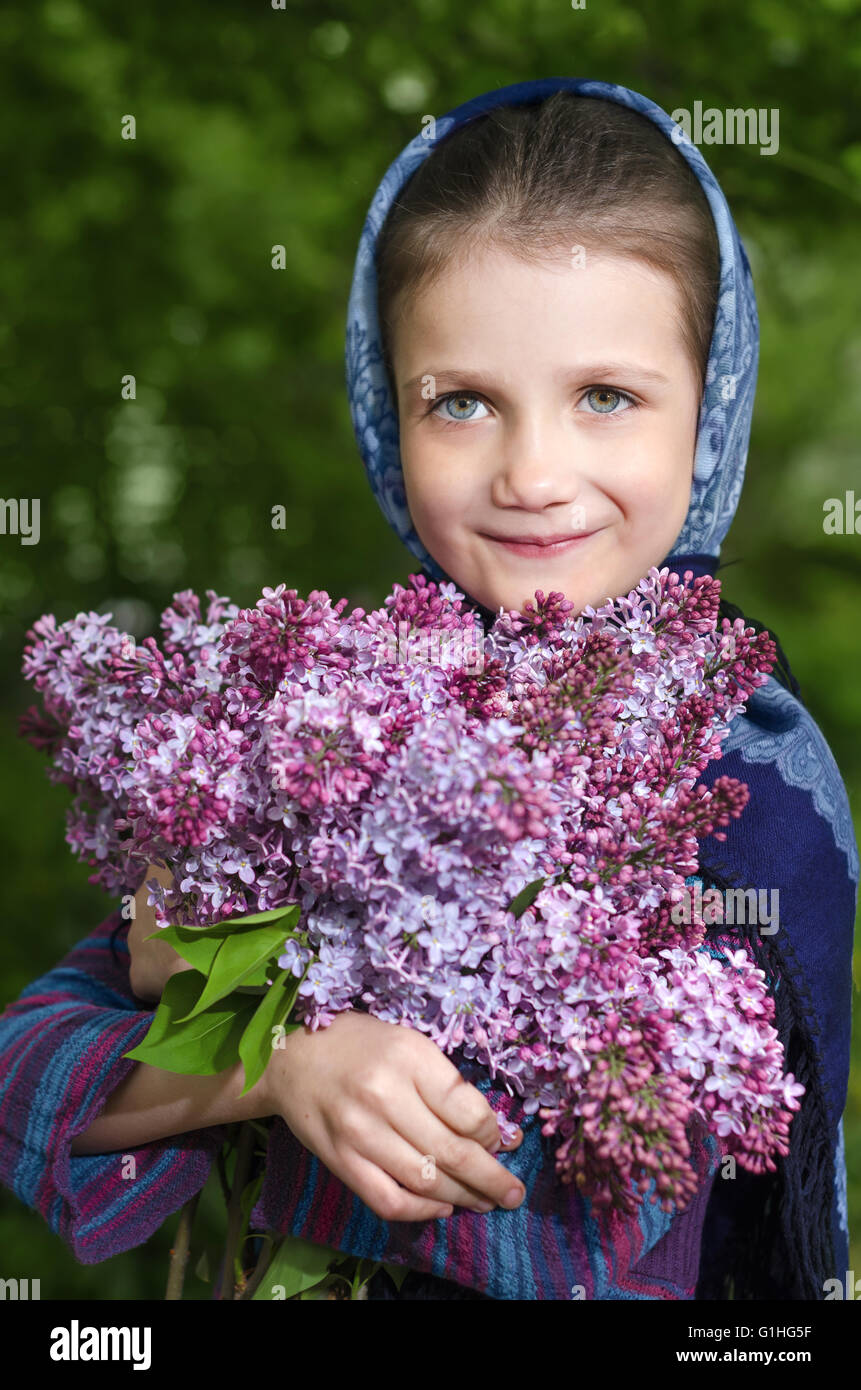 Little girl with lilacs blooming in the hands Stock Photo - Alamy