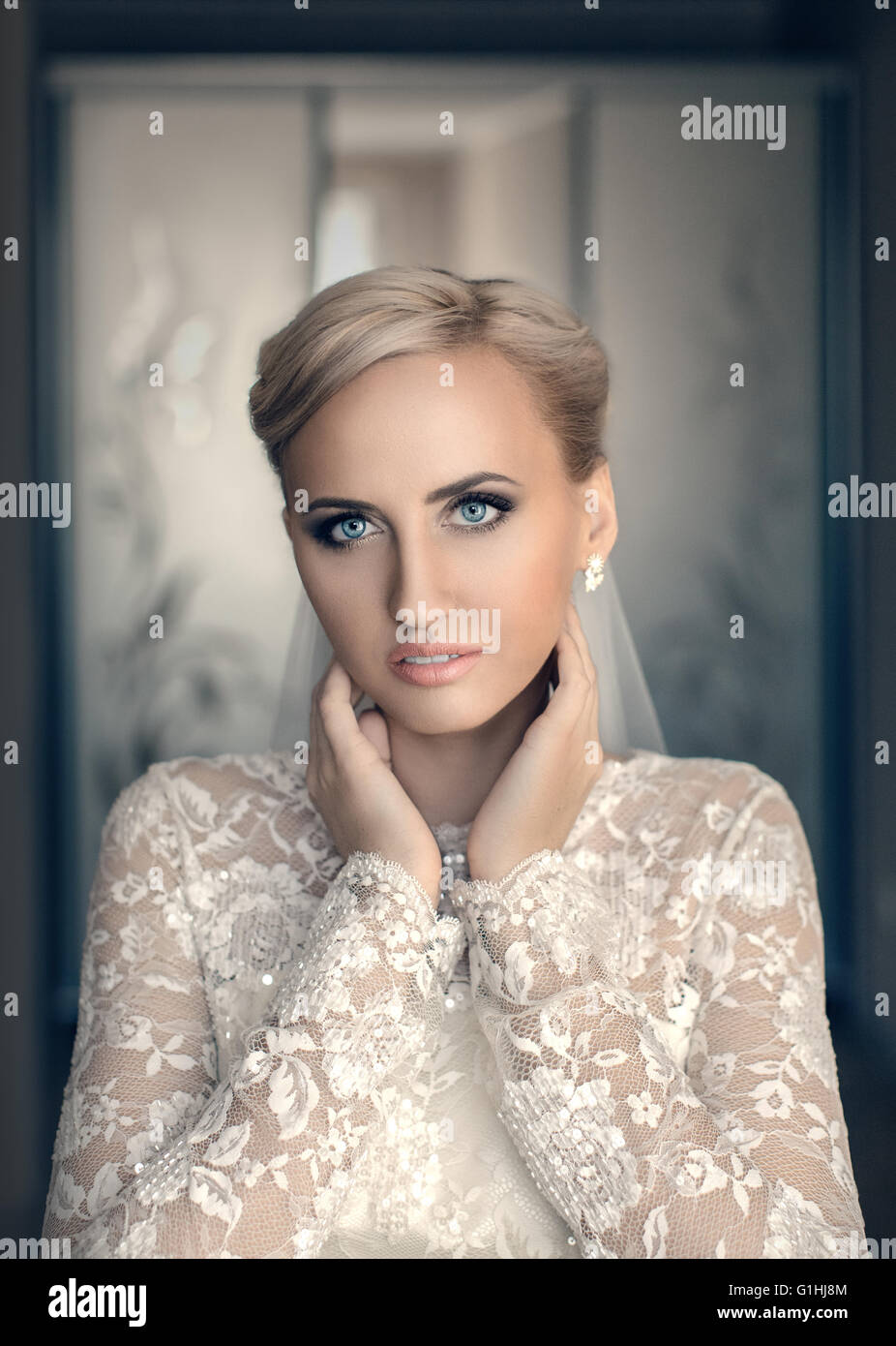 Blond bride with blue eyes in a white dress Stock Photo - Alamy