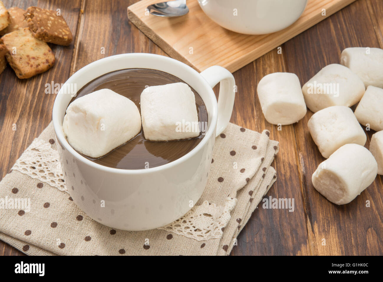 Mug filled with homemade hot chocolate and marshmallow, cookies on wooden table Stock Photo