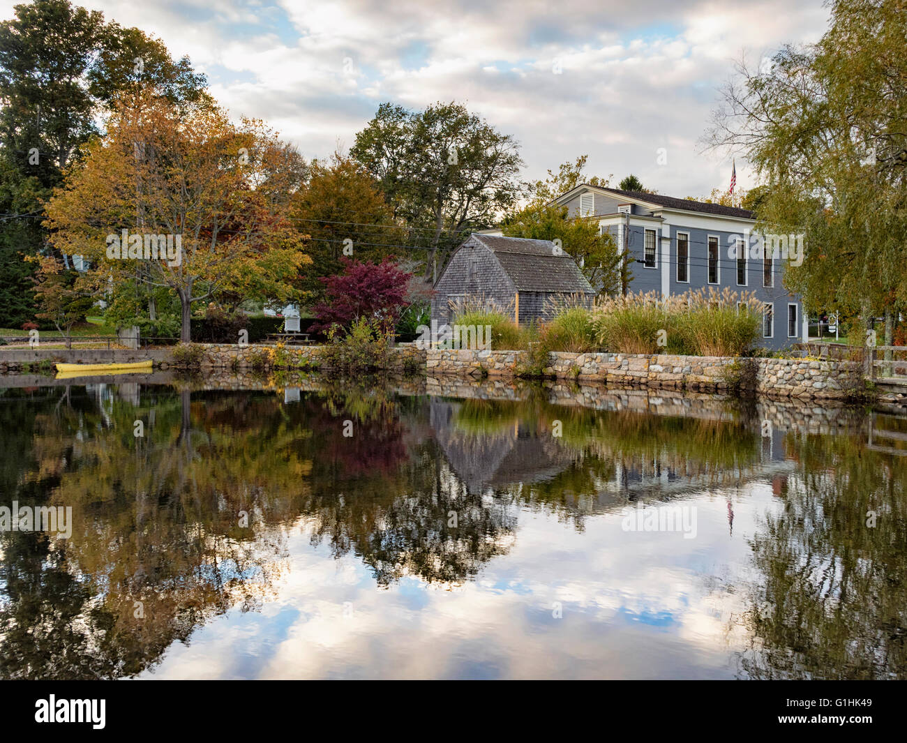 Dexter Grist Mill, Sandwich MA Cape Cod Massachusetts USA seen across the millpond in autumn fall colors colours reflections in the pond Stock Photo