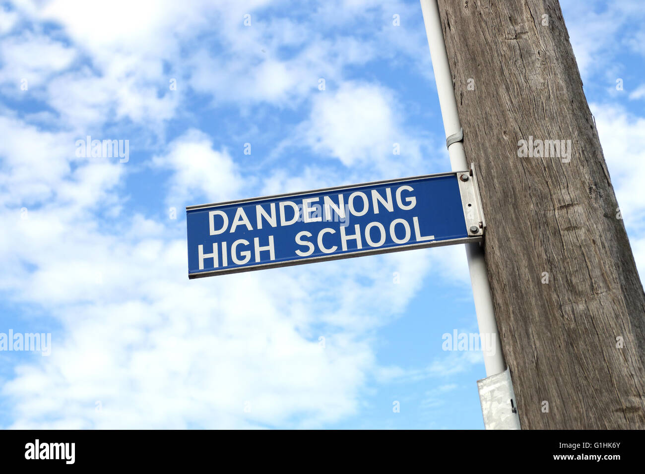 Dandenong High School signboard on wooden pole against the sky Stock