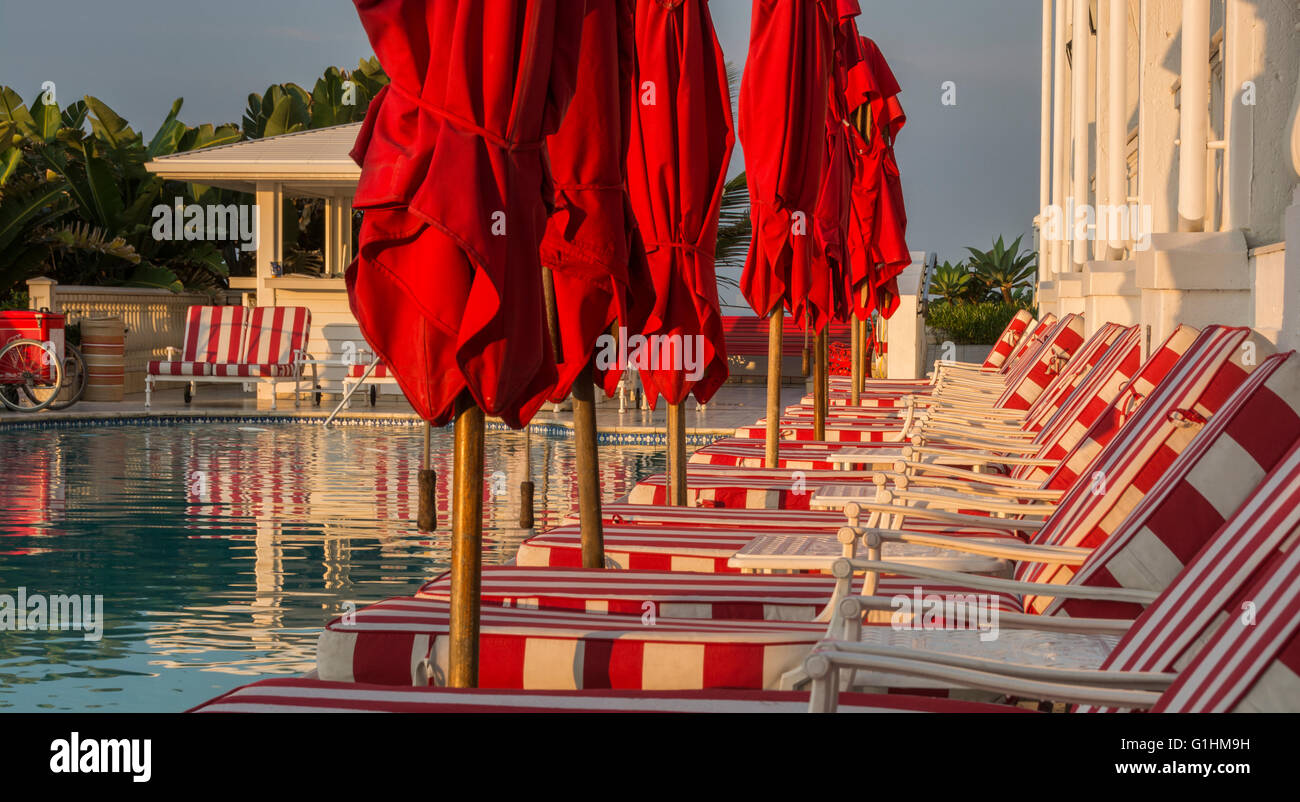 Sun loungers and red parasols waiting for guests by the pool of a luxury hotel in Durban