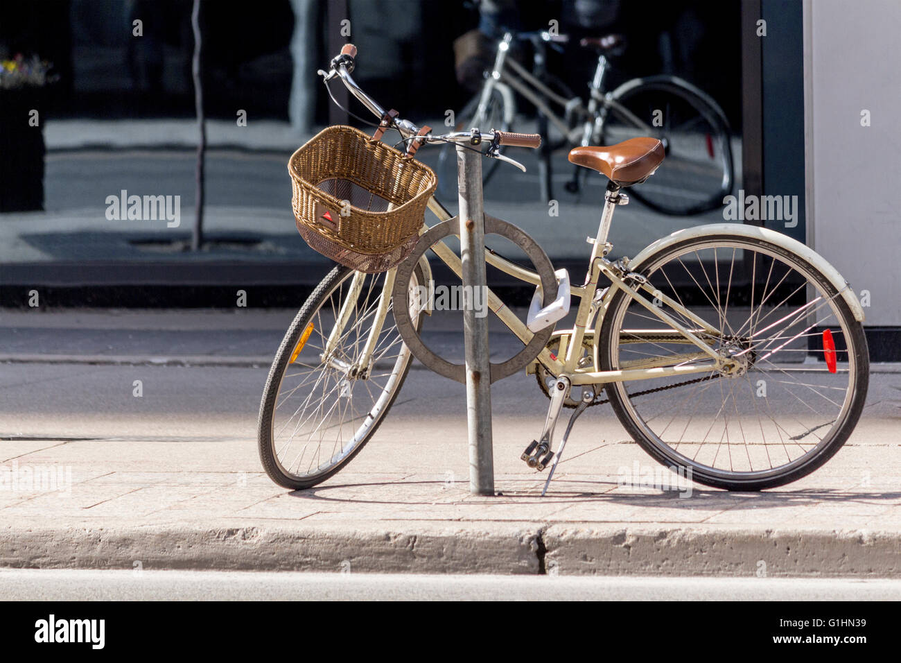 Woman's bicycle with basket locked to bicycle stand in downtown Toronto, Ontario, Canada Stock Photo